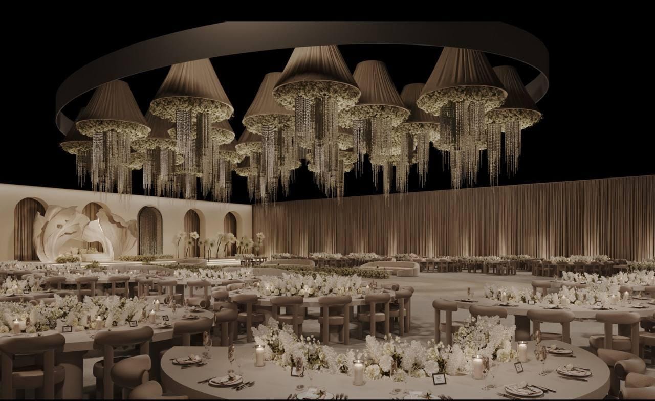 Banquet layout with a circular chandelier cluster and round guest tables by RAW Group